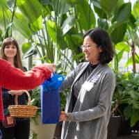 Female party goer receiving gift bag from colleague